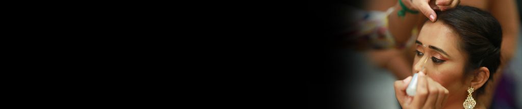 wedding makeup artist applying eye liner to a bride