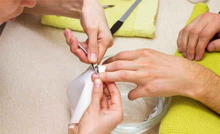 Man's hand getting nail care treatment by a manicure specialist at skulpt chennai